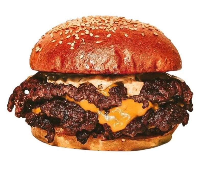 A double smash burger with melted cheese and sauce on a sesame bun